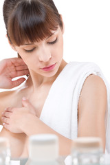 Obraz na płótnie Canvas Body care: Young woman applying lotion