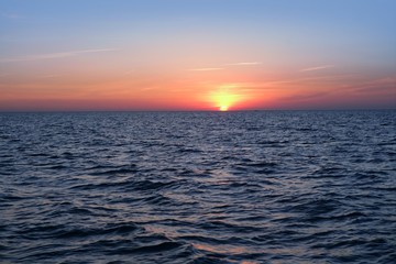Obraz premium Beautiful sunset sunrise over blue sea ocean red sky