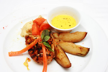Grilled chicken with potato wedges isolated