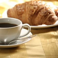 close up image of croissant and tea