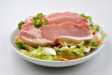 raw organic pork chop and salad