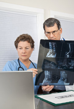 Doctor and Nurse Reading Spinal MRI Scan at the Computer