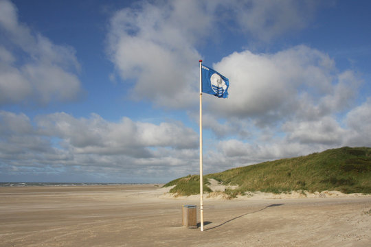Blaue Flagge am breiten Strand