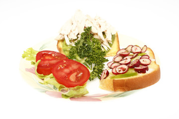 A half chicken sandwich on a plate isolated on white.