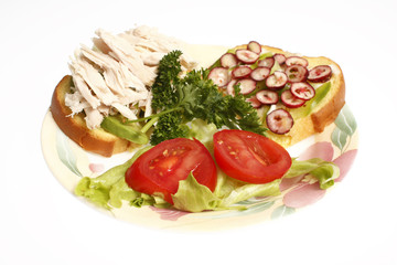 A half chicken sandwich on a plate isolated on white.