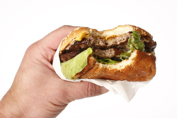 A fast food cheeseburger with a bite taken out of it.