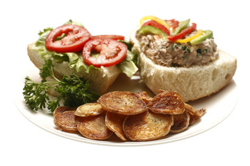 A tuna salad sandwich with potato chips.