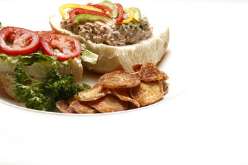 A tuna salad sandwich with potato chips.
