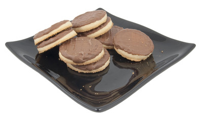 chocolate and toffee biscuits on plate isolated on white