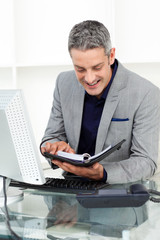 Fototapeta premium Smiling businessman consulting his agenda