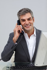 Smiling mature male executive talking on phone