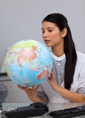 Concentrated businesswoman looking at a globe