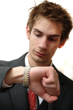 Attractive Young businessman in suit checks his watch