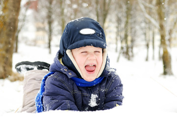 Fototapeta na wymiar boy at snowy winter outdoors