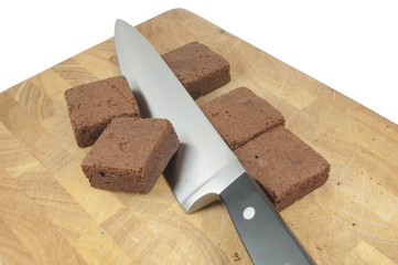 carving knife and brownies on wooden board on white