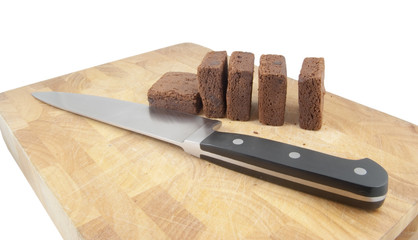 knife and brownies on chopping board on white background