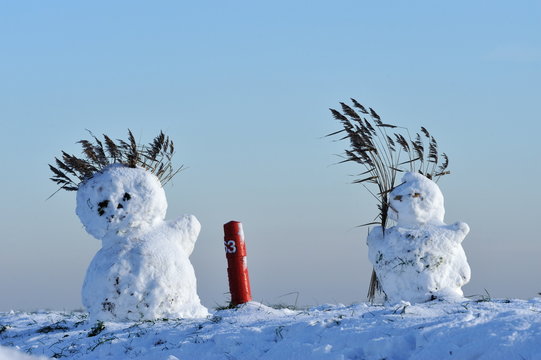 snowmen on dike in the netherlands