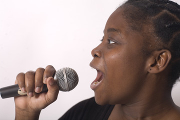 jeune femme noire chante dans un micro emotion