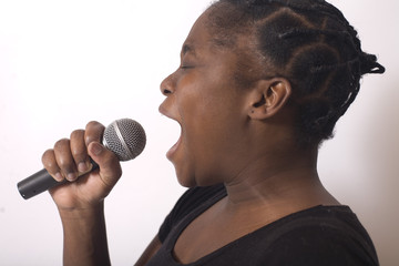 femme noire chante dans un micro avec emotion