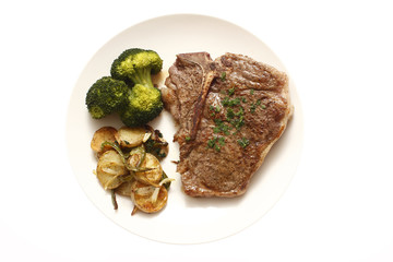 T-Bone steak dinner with sides of potatoes and broccoli