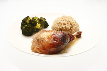A plate of oven baked chicken with broccoli and rice