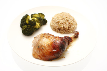 A plate of oven baked chicken with broccoli and rice