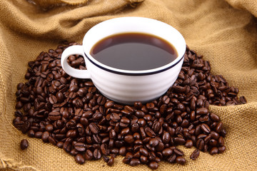 Cup of coffee sitting in a bed of coffee beans