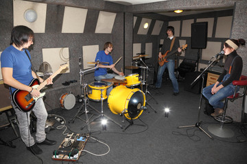 vocalist girl, guitarists and drummer in studio