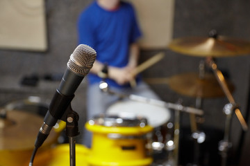 microphone in studio. drummer in out of focus