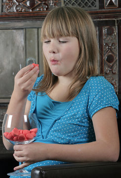 jeune fille s'empifrant de bonbons &agrave; la fraise