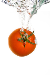 A tomato falling into clear water
