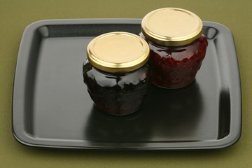 Two jars of jam on a tray