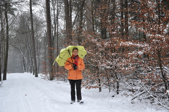 Senior Woman Walking In A Snowy Forest