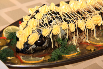 roasted sturgeon decorated with lemons, seaproducts, vegetableso