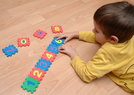 young boy playing with numbers