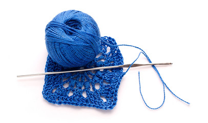 A ball of blue yarn with knitting and crochet pattern crochet