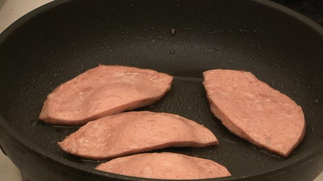 Sausage is fried on a frying pan timelapse