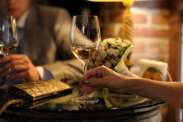 Groom's and bride's hands holding wine glasses