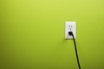 black cable plugged in a white electric outlet - obrazy, fototapety, plakaty