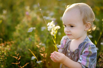 Little nice baby walking in a meadow