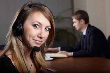 young female talk by  headset with microphone in office