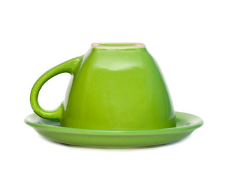 Green inverted cup on a saucer. Isolated on white background.