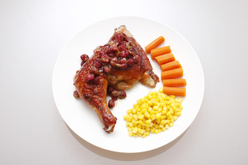 dish of cranberry chicken with a side of corn and carrots