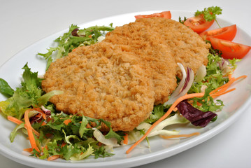 breaded fish steak with grilled onion on a plate