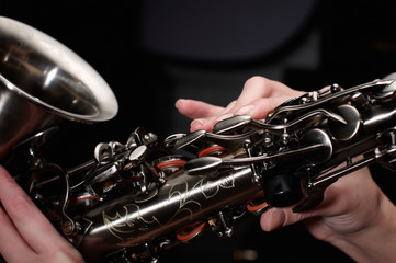 Fototapeta premium hand on buttons of saxophone