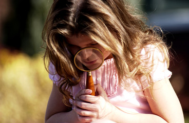 Girl looking through magnifying glass