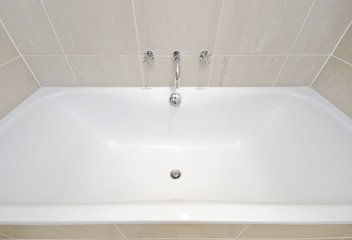 modern bath tub with designer water tap