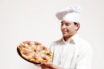 Portrait of happy attractive cook with a pizza in hands