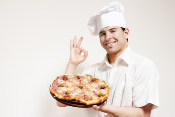 Portrait of happy attractive cook with a pizza in hands
