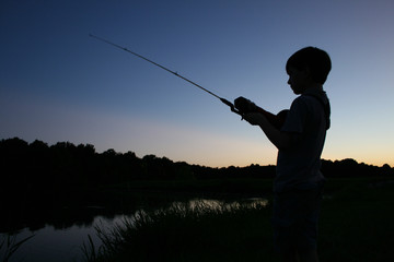 boy fishing in silhouette